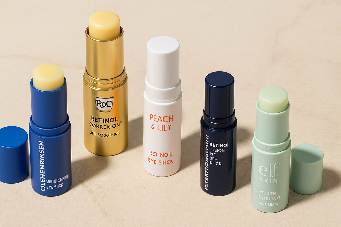 Five popular retinol eye sticks in colorful packaging are arranged on a marble surface, with caps off to reveal the balm inside, under soft lighting.